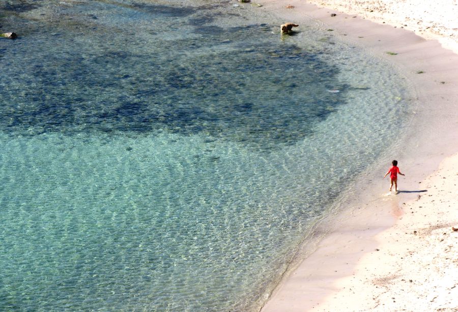 Un enfant court au bord de l'eau, plage de la Batterie à Marseille