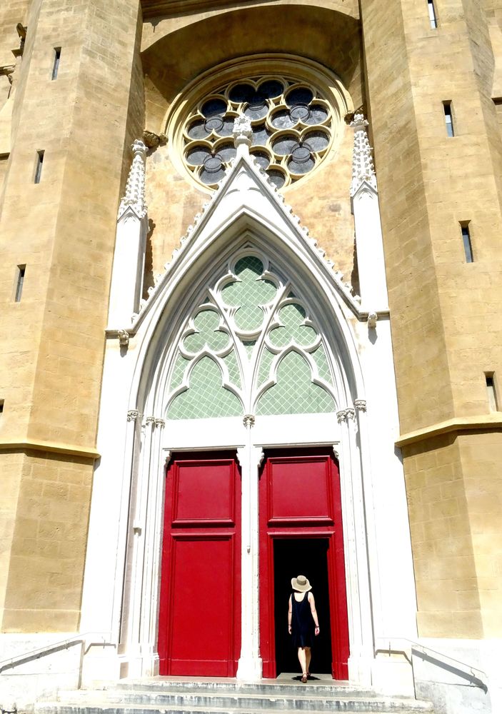 Une femme au chapeau rentre dans une église à Aix-en-Provence.