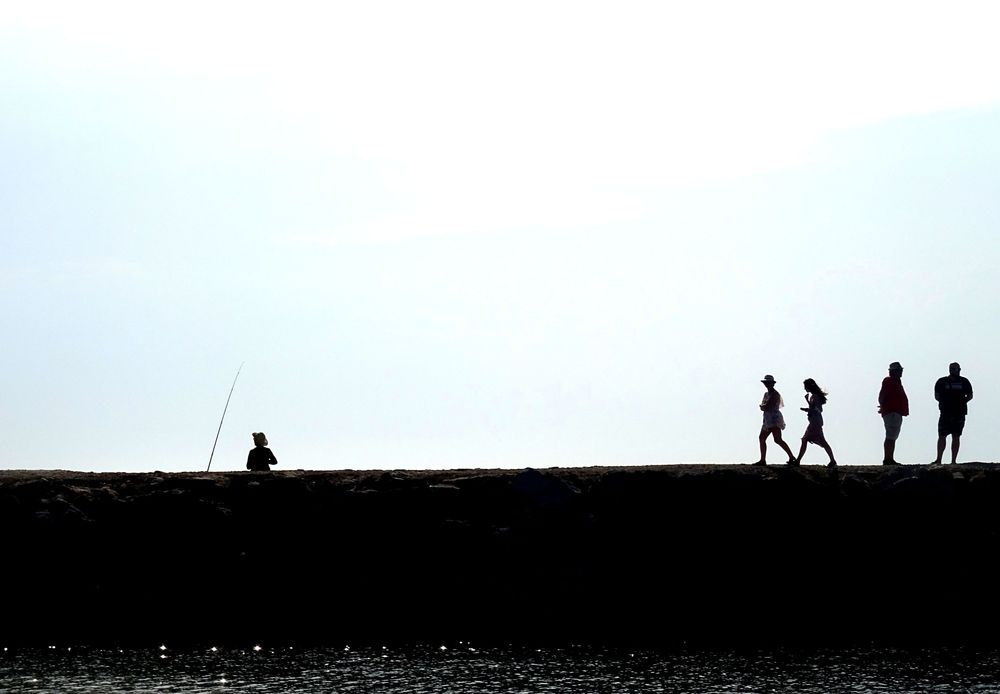 Des ombres se meuvent sur une jetée.