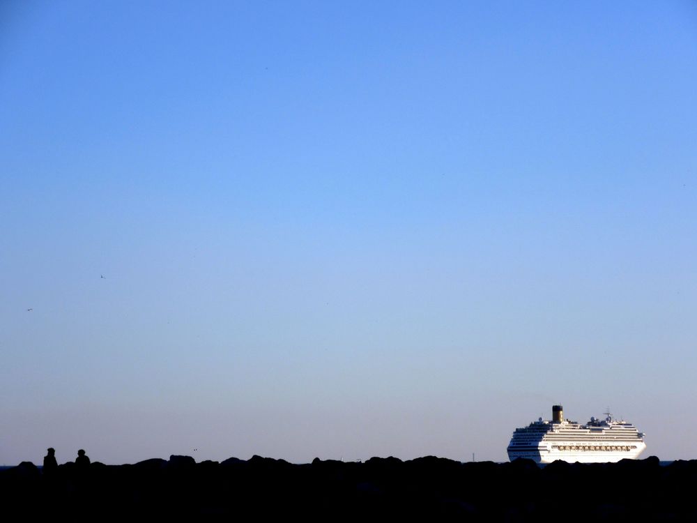 Un bateau de croisières semble porté par les roches de la jetée à Corbières à Marseille.