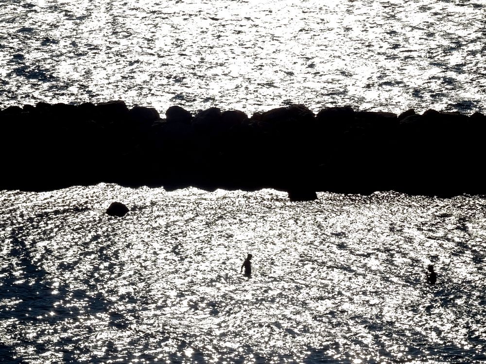 L'ombre d'une personne en train de se baigner sur la plage du Prophète à Marseille.